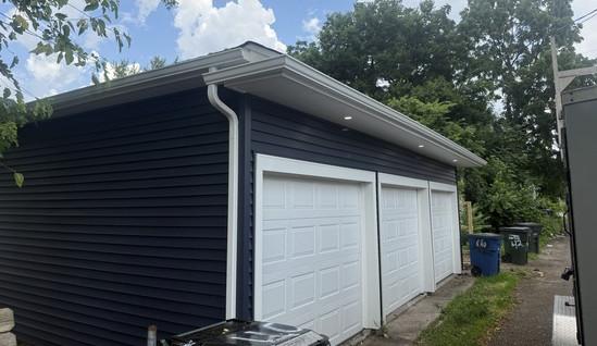 Detached garage with new navy siding and a fresh shingle roof in Dayton, Ohio