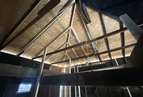 Interior of a garage showing new roof framing and sheathing