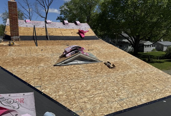 New roof sheathing and underlayment installed around a skylight opening